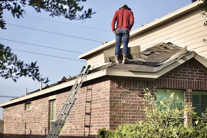 Professional roofer working on a residential roof in Cameron